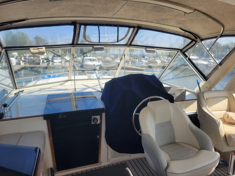 Slide: The Image of 1986 Chris-Craft 381 Catalina boat interior with helm, seats, and marina view. - 7
