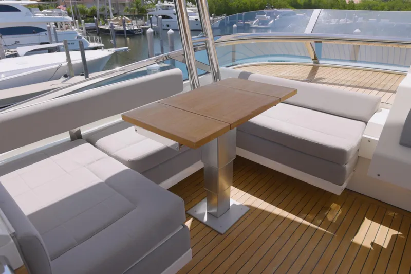 Slide: The Image of Luxurious seating area on 2014 Fairline Squadron 78 Custom yacht with wooden table and marina view. - 18