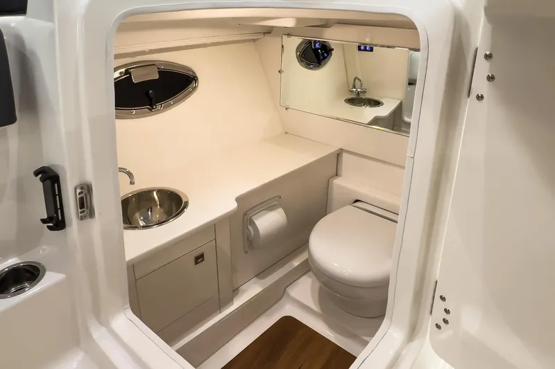 Slide: The Image of 2026 Robalo R277 Dual Console boat bathroom with sink, toilet, and mirror. - 9