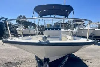 Slide: The Image of 2023 Boston Whaler 170 Montauk boat with canopy, docked under clear blue sky. - 4