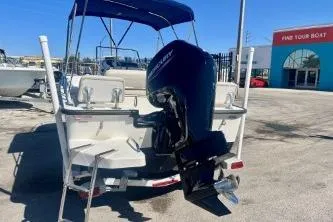 Slide: The Image of 2023 Boston Whaler 170 Montauk boat with outboard motor, parked outdoors. - 5