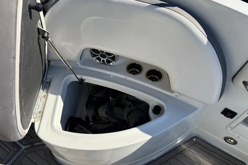 Slide: The Image of 2019 Crownline Eclipse E255 XS boat storage compartment with open lid and speaker. - 15