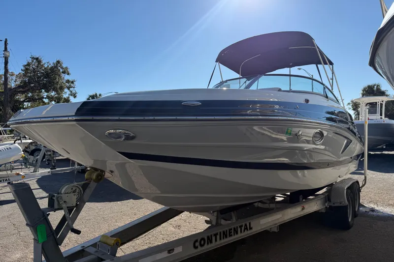 Slide: The Image of 2019 Crownline Eclipse E255 XS boat on trailer under clear blue sky. - 2