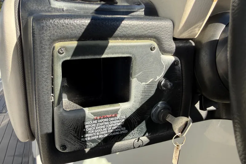 Slide: The Image of 2019 Crownline Eclipse E255 XS dashboard with ignition key and warning label. - 24