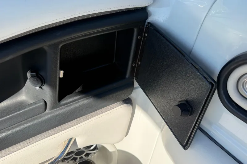 Slide: The Image of 2019 Crownline Eclipse E255 XS storage compartment with open door and sleek interior design. - 30