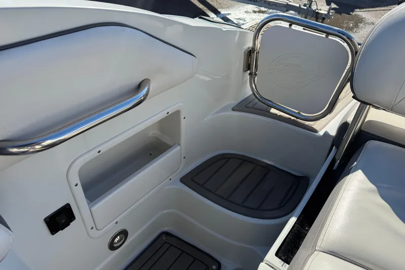 Slide: The Image of 2019 Crownline Eclipse E255 XS boat interior with storage compartment and seating area. - 7