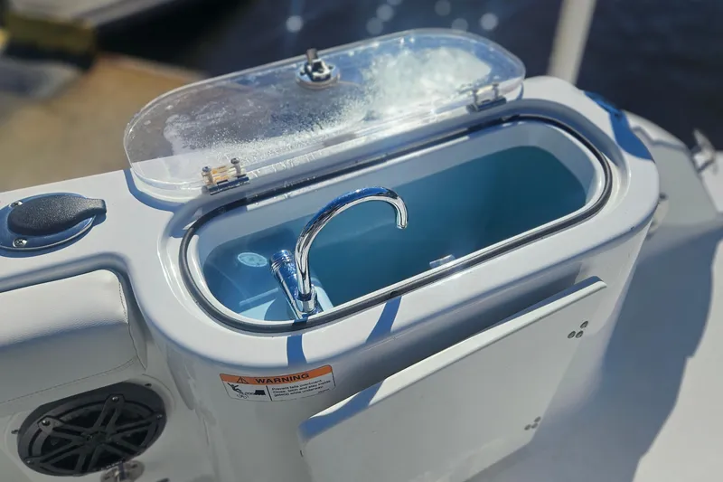 Slide: The Image of Livewell on 2021 Wellcraft 242 Fisherman boat, featuring a clear lid and faucet. - 14