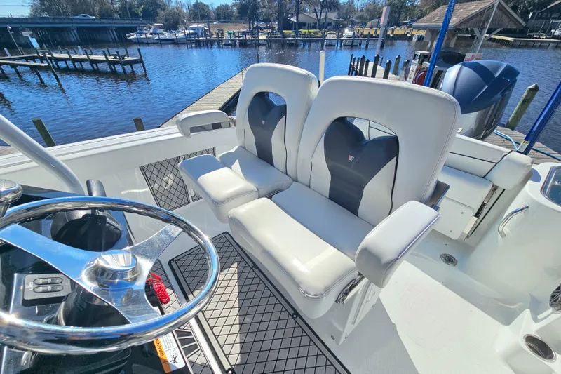 Slide: The Image of 2021 Wellcraft 242 Fisherman boat interior with dual seats and steering wheel at dock. - 16