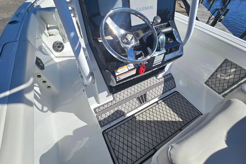 Slide: The Image of 2021 Wellcraft 242 Fisherman boat cockpit with steering wheel and Garmin display. - 17