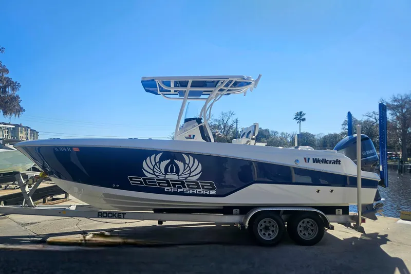 Slide: The Image of 2021 Wellcraft 242 Fisherman boat on trailer, blue and white design, sunny day background. - 6