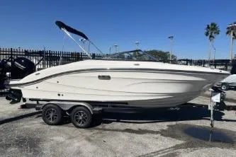 The Image of 2024 Sea Ray SPX 210 Outboard boat on trailer, parked outdoors under clear blue sky. - 1