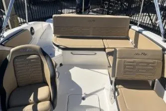 Slide: The Image of 2024 Sea Ray SPX 210 Outboard boat interior with beige seating and sleek design. - 12