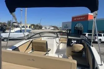 Slide: The Image of 2024 Sea Ray SPX 210 Outboard boat with beige seating, docked at a marina. - 7