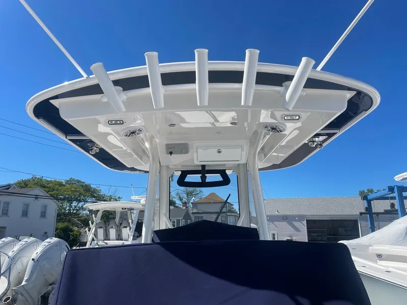 Slide: The Image of 2025 Regulator 31 boat with T-top and rod holders, blue sky. - 8