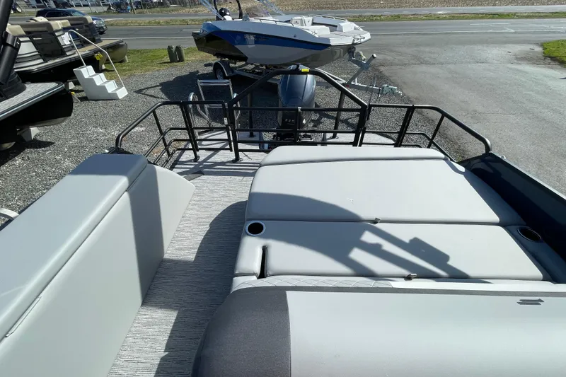 Slide: The Image of 2026 Starcraft EXS 1 Q DH boat interior with seating and railing, parked outdoors. - 2