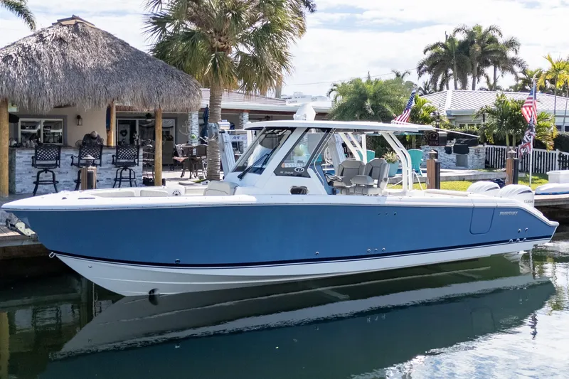 The Image of 2023 Pursuit S 328 Sport boat docked by a tropical waterfront bar. - 0