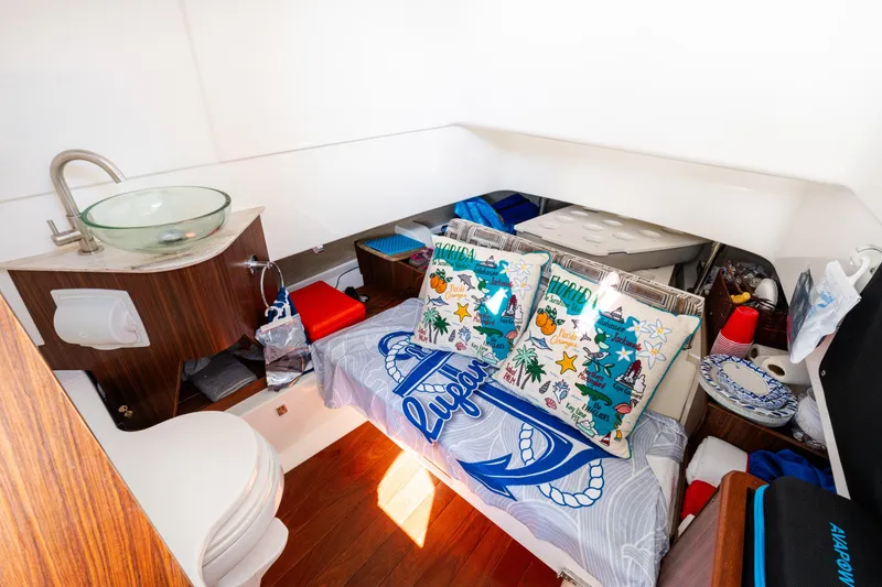 Slide: The Image of 2023 Pursuit S 328 Sport cabin with cozy bedding, pillows, and compact sink area. - 10