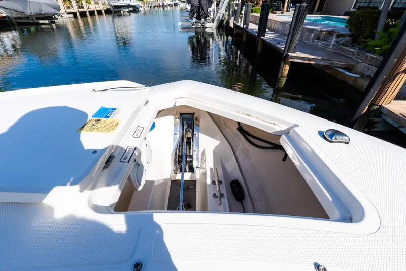 Slide: The Image of 2023 Pursuit S 328 Sport boat anchor compartment in a marina setting. - 13