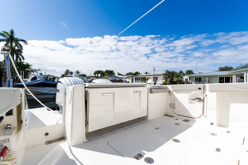 Slide: The Image of 2023 Pursuit S 328 Sport boat deck with clear sky and palm trees. - 5