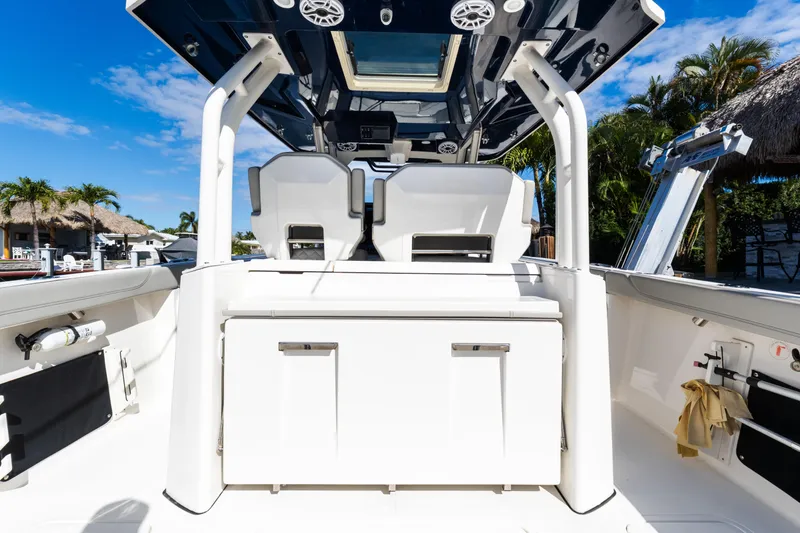 Slide: The Image of 2023 Pursuit S 328 Sport boat interior with seating and storage, under clear blue sky. - 6