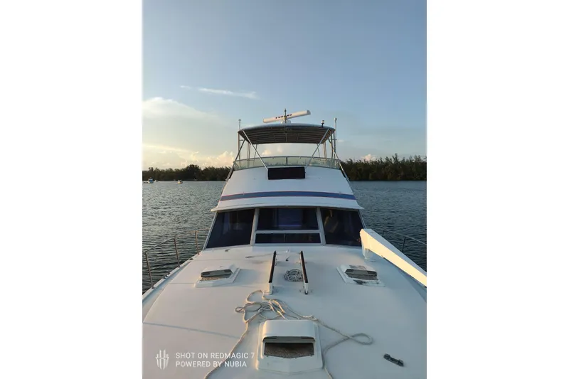 Slide: The Image of 1977 Bertram 46 Convertible yacht on calm water at sunset. - 5