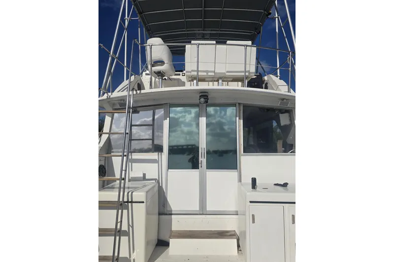 Slide: The Image of 1977 Bertram 46 Convertible yacht with upper deck and sliding glass doors. - 6