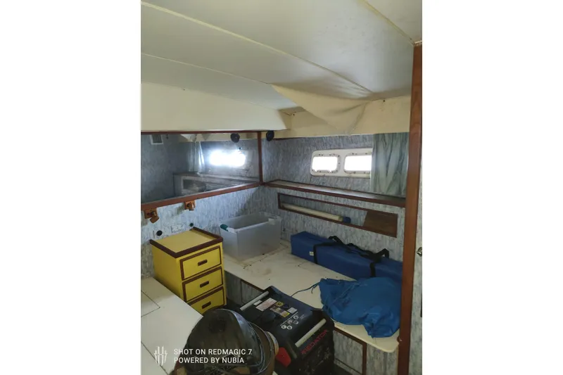 Slide: The Image of 1977 Bertram 46 Convertible interior with storage, windows, and yellow drawers. - 7