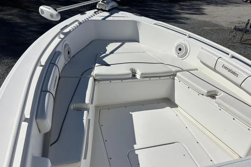 Slide: The Image of 2008 Everglades 243 Center Console boat interior with white seating and storage compartments. - 12