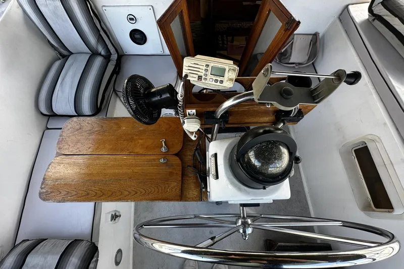 Slide: The Image of 1975 Morgan Out Island 51 cockpit with wooden table, steering wheel, and navigation instruments. - 13