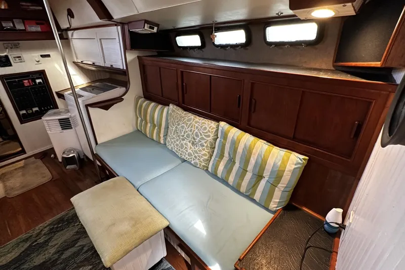 Slide: The Image of 1975 Morgan Out Island 51 yacht interior with cozy seating and wooden cabinetry. - 18