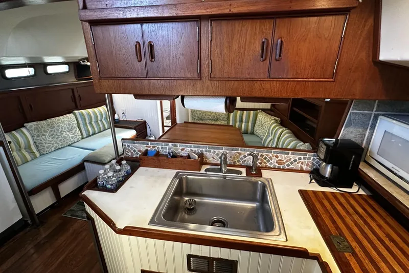 Slide: The Image of 1975 Morgan Out Island 51 yacht interior with cozy seating and compact kitchen area. - 19