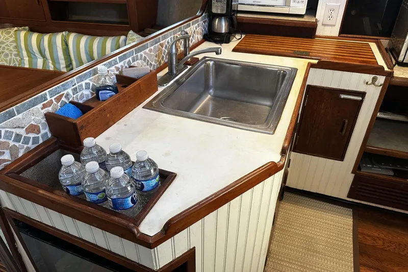 Slide: The Image of 1975 Morgan Out Island 51 yacht kitchen with sink, countertop, and water bottles. - 20