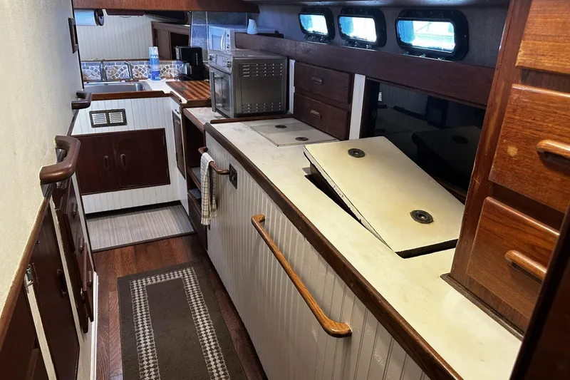 Slide: The Image of 1975 Morgan Out Island 51 yacht interior with wooden cabinetry and kitchen appliances. - 23