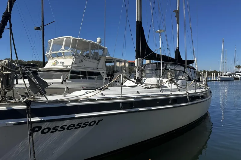 Slide: The Image of 1975 Morgan Out Island 51 sailboat docked in a marina under clear blue skies. - 3