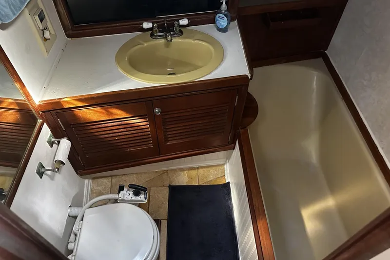 Slide: The Image of 1975 Morgan Out Island 51 yacht bathroom with sink, toilet, and shower area. - 32