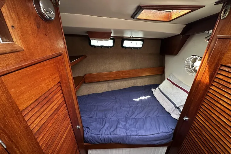 Slide: The Image of 1975 Morgan Out Island 51 cabin interior with wooden finish and cozy bedding. - 34