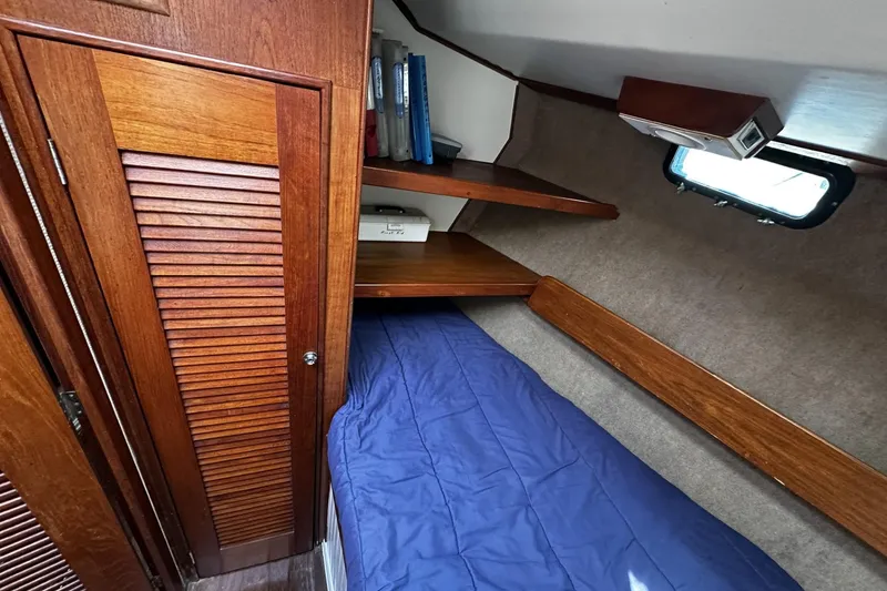 Slide: The Image of 1975 Morgan Out Island 51 cabin interior with wooden shelves and blue bedding. - 36