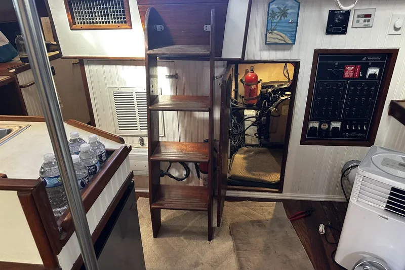 Slide: The Image of 1975 Morgan Out Island 51 yacht interior with wooden ladder, control panel, and engine room access. - 45