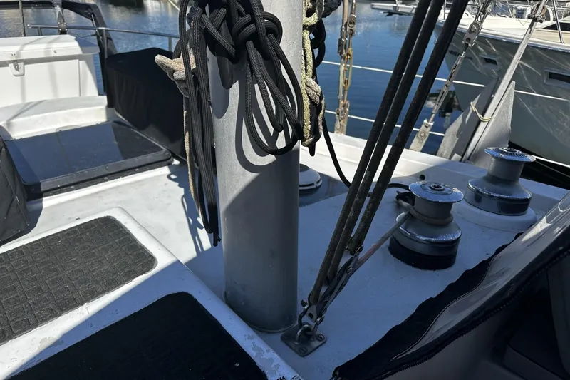 Slide: The Image of 1975 Morgan Out Island 51 sailboat deck with winches and rigging at a marina. - 52