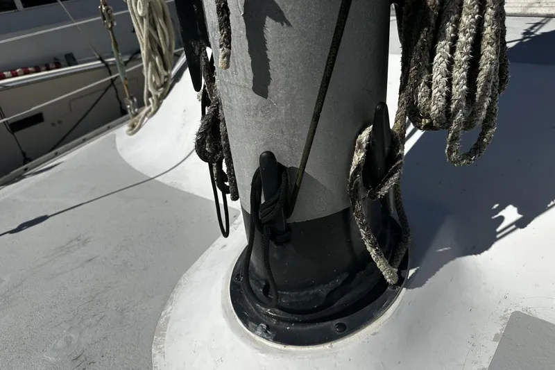 Slide: The Image of 1975 Morgan Out Island 51 sailboat mast with ropes and cleats on deck. - 53