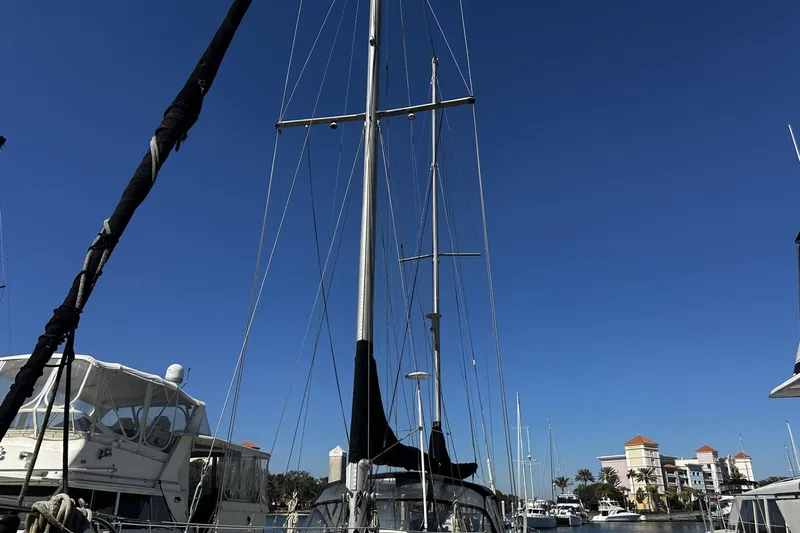 Slide: The Image of 1975 Morgan Out Island 51 sailboat docked at marina under clear blue sky. - 54