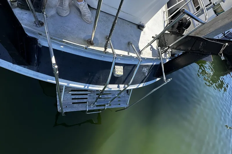 Slide: The Image of 1975 Morgan Out Island 51 yacht stern with boarding ladder over water. - 59