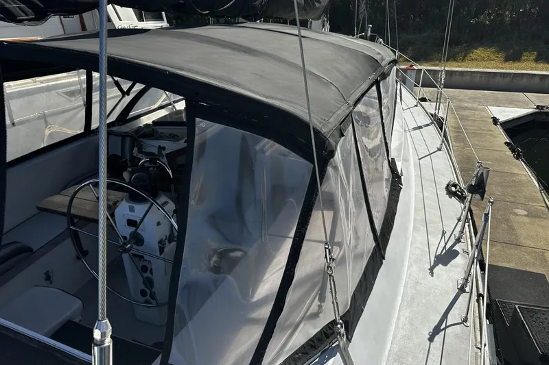 Slide: The Image of 1975 Morgan Out Island 51 sailboat with covered cockpit and steering wheel, docked at marina. - 6