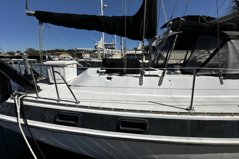 Slide: The Image of 1975 Morgan Out Island 51 sailboat docked at marina under clear blue sky. - 60
