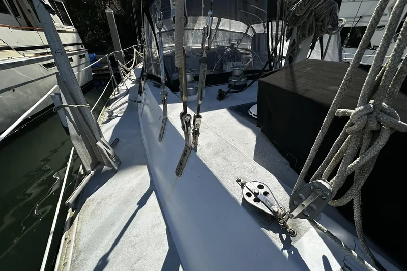 Slide: The Image of 1975 Morgan Out Island 51 sailboat deck with rigging and ropes in marina. - 62