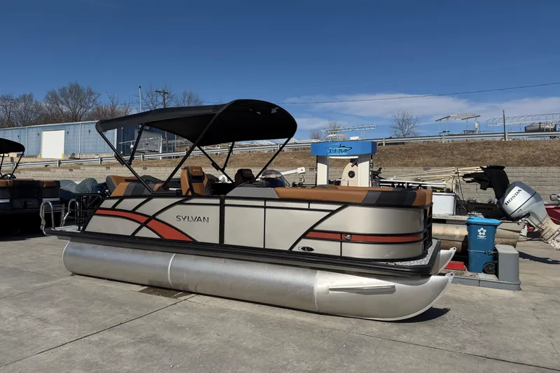 The Image of 2026 Sylvan L-1 LZ DH pontoon boat with canopy, docked outdoors. - 0