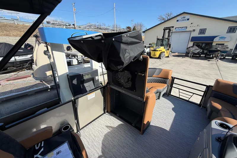 Slide: The Image of 2026 Sylvan L-1 LZ DH boat interior with seating and storage, docked at a marina. - 16