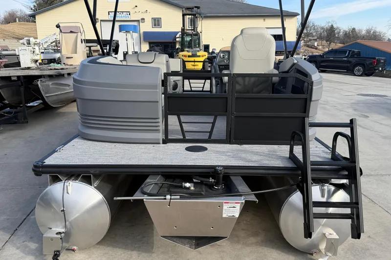 Slide: The Image of 2026 Sylvan A-18 pontoon boat, rear view, parked on concrete lot. - 10