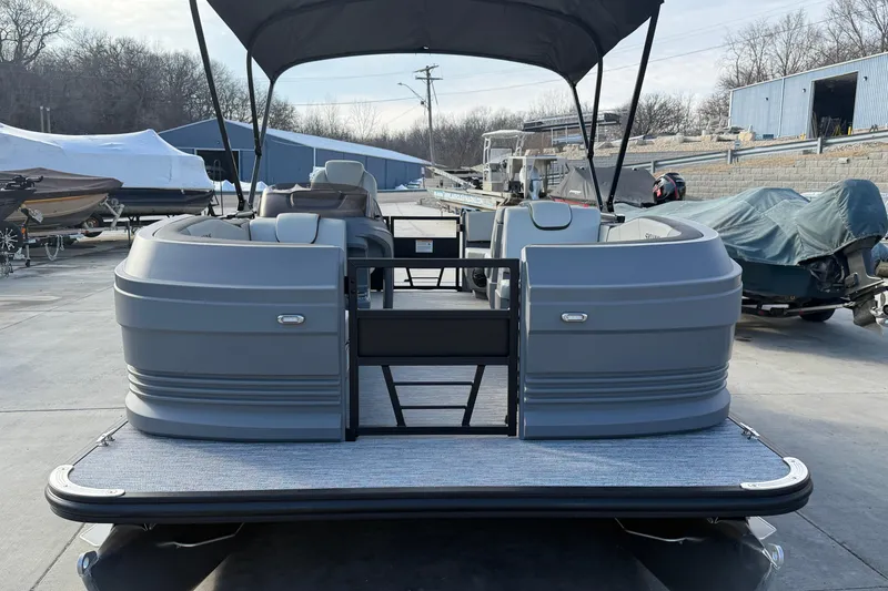 Slide: The Image of 2026 Sylvan A-18 pontoon boat with canopy, parked in a marina setting. - 7