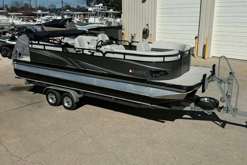 Slide: The Image of 2020 Avalon GS Quad Lounger 23' pontoon boat on trailer, parked outside a warehouse. - 11